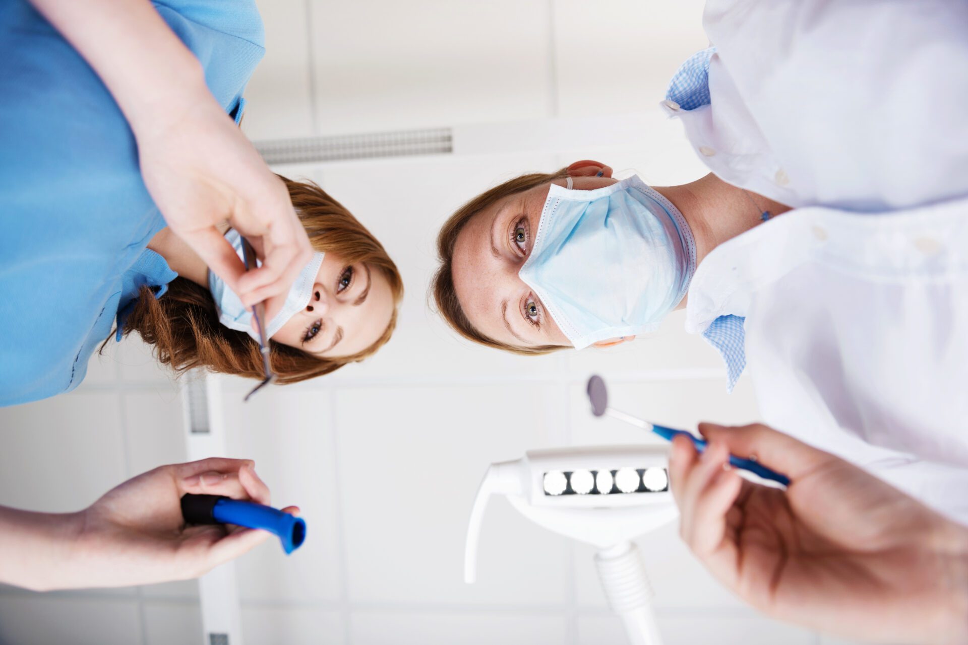 Directly below view of female dentists using dental tools in clinic